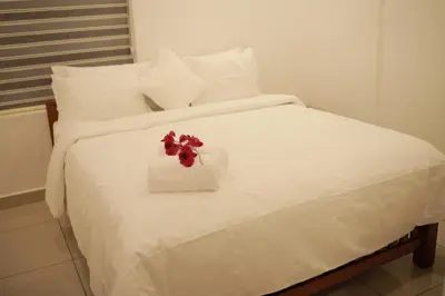 a white bed with a flower in a box on it at Humblebee Retreat Tattekkad in Kuttampuzha