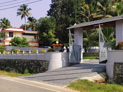 a bridge over a road in front of a building at Humblebee Retreat Tattekkad in Kuttampuzha