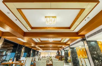 a dining room with chairs and a ceiling with a chandelier at The Grand Cliff Resort Munnar in Viripara