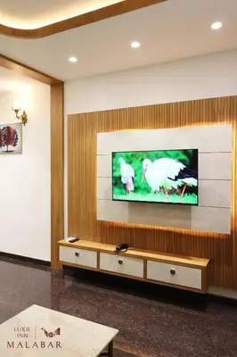 a living room with a flat screen tv on a wall at LUXIE INN MALABAR in Perintalmanna