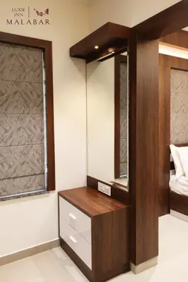 a dressing room with a mirror and a dresser at LUXIE INN MALABAR in Perintalmanna