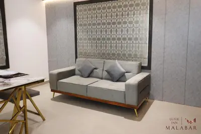 a couch with pillows on it in a living room at LUXIE INN MALABAR in Perintalmanna