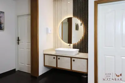 a bathroom with a sink and a mirror at LUXIE INN MALABAR in Perintalmanna