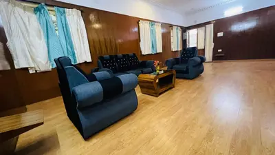 a living room with couches and chairs and a table at Hidden heritage ins in Ooty
