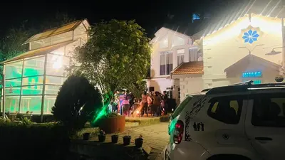 a group of people standing outside a building at night at Hidden heritage ins in Ooty
