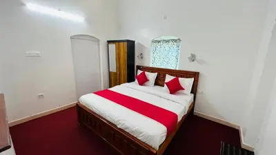 a bedroom with a bed with red and white sheets at Hidden heritage ins in Ooty
