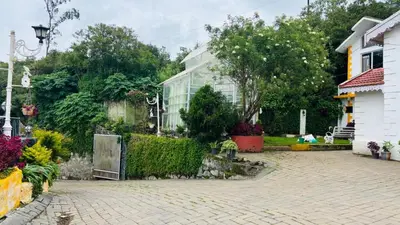 a house with a garden and a brick driveway at Hidden heritage ins in Ooty