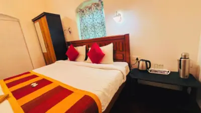 a hotel room with a bed with red pillows at Hidden heritage ins in Ooty