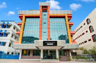 a large building with a sign in front of it at Super Townhouse Mysore Central in Mysore