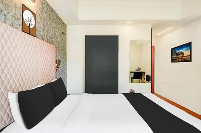 a bedroom with a white bed and a black door at Super Townhouse Mysore Central in Mysore