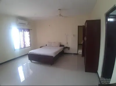 a bedroom with a bed in a room with a window at Renu Residency on the way to Isha yoga centre and near Maruthamalai in Marudhamalai