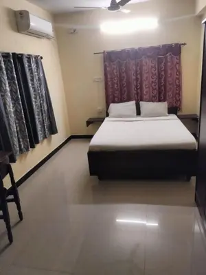 a bedroom with a bed in a room with a window at Renu Residency near Maruthamalai and on the way to Adiyogi Isha yoga Centre in Marudhamalai