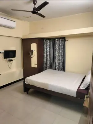 a bedroom with a bed and a ceiling fan at Renu Residency near Maruthamalai and on the way to Adiyogi Isha yoga Centre in Marudhamalai