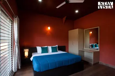 a bedroom with a bed in a red room at Golden Apex by VEO - Part of StayVista in Hampāpura