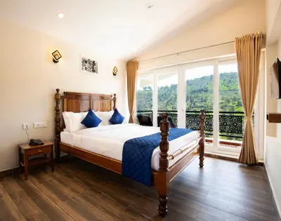a bedroom with a bed and a large window at COASTAL GRAND RESORT - KOTAGIRI in Kotagiri