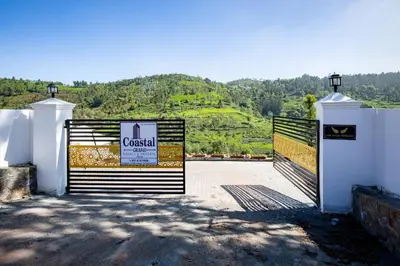 a gate with a sign in front of a mountain at COASTAL GRAND RESORT - KOTAGIRI in Kotagiri