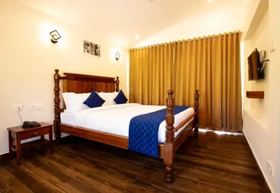 a bedroom with a bed and a wooden floor at COASTAL GRAND RESORT - KOTAGIRI in Kotagiri