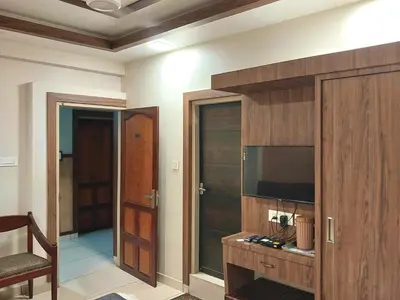 a living room with a tv and a entertainment center at Hotel Royal Wings in Elūr