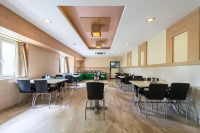 a restaurant with tables and chairs in a room at Treebo ESS Grande in Coimbatore
