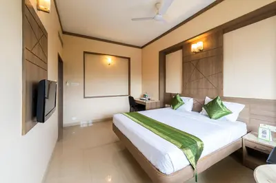 a hotel room with a bed and a tv at Treebo ESS Grande in Coimbatore