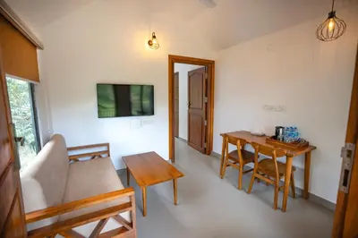a living room with a table and a couch at Feel Free Retreat in Kalpetta