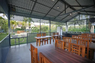 an empty restaurant with wooden tables and chairs at Feel Free Retreat in Kalpetta