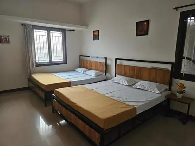 two beds in a room with two windows at SHI's Velliangiri 3BHK Individual villa Near Isha Adiyogi, Coimbatore in Alāndurai