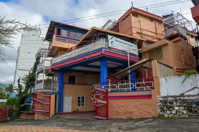 a building with a blue and red building at Vijaya Deepa Guest House by LexStays in Coonoor