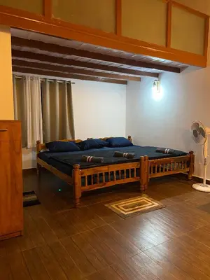 a bedroom with a large wooden bed in a room at Coorg klusters estate stay in Virajpet