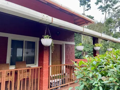 a porch of a house with chairs and plants at Coorg klusters estate stay in Virajpet