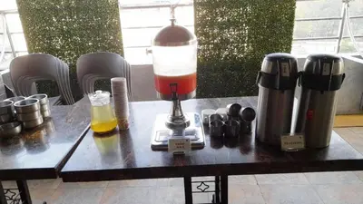 a table with a coffee maker and a blender at Hotel Roopa in Mysore
