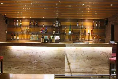 a bar with a counter with bottles of wine at Hotel Roopa in Mysore