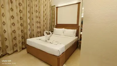 a bedroom with a bed with a towel on it at Hotel Roopa in Mysore