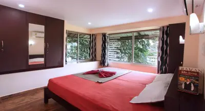 a bedroom with a large red bed with a window at Elephant Pass Ayurveda & Yoga Retreat in Malayāttūr