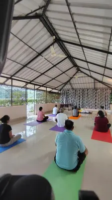 a group of people sitting on the floor in a tent at Elephant Pass Ayurveda & Yoga Retreat in Malayāttūr