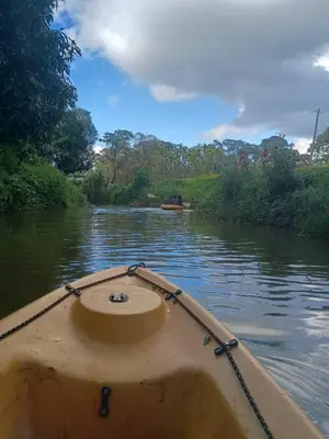 a boat in the water on a river at Nature Spot Cottages Coorg in Kurchi