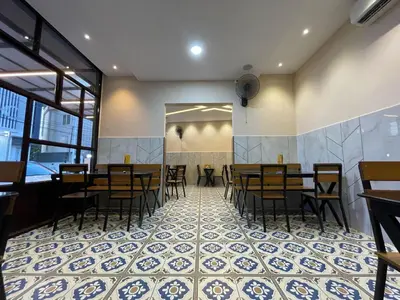 a restaurant with tables and chairs on a tiled floor at Hotel Deepakam Inn in Palakkad
