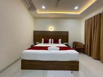 a bedroom with a large bed with red pillows at Hotel Deepakam Inn in Palakkad