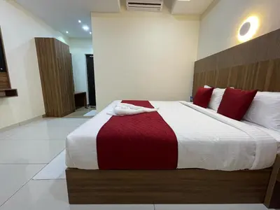 a bedroom with a large bed with red pillows at Hotel Deepakam Inn in Palakkad