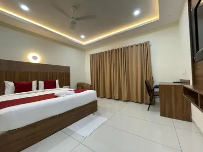 a bedroom with a large bed and a television at Hotel Deepakam Inn in Palakkad
