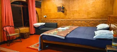 a bedroom with a bed and a chair in a room at Angels Nest Home stay 2 Acra private plantation Mountain area balconey SunRice view Nearby Ngarhole wild life , Tholpetty wild life , Pakshipathalam Bird santuary , Kuruva island # Thirunelly & Thrissilery Temple Near by Secure Stay Wayanad Kerala in Chekadi