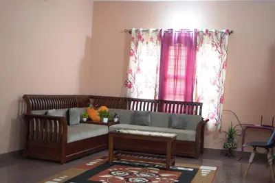 a living room with a couch and a window at Coorg Stream Side Homestay in Ponnampet