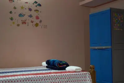 a bedroom with a bed and a blue cabinet at Coorg Stream Side Homestay in Ponnampet