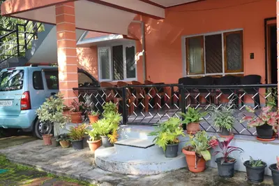 a house with a bunch of potted plants on the front porch at Coorg Stream Side Homestay in Ponnampet