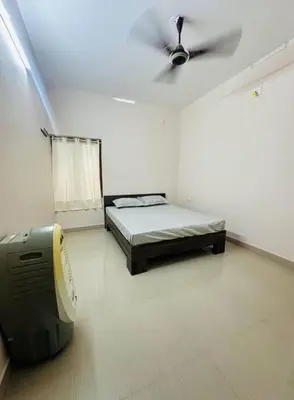 a bedroom with a bed and a ceiling fan at Homestay Guruvayur, 2 AC Bedrooms, Hall, Veranda, Kitchen in Guruvāyūr