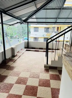 an empty building with a roof and a tile floor at Homestay Guruvayur, 2 AC Bedrooms, Hall, Veranda, Kitchen in Guruvāyūr