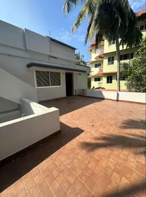 a brick patio in front of a house with a palm tree at Homestay Guruvayur, 2 AC Bedrooms, Hall, Veranda, Kitchen in Guruvāyūr