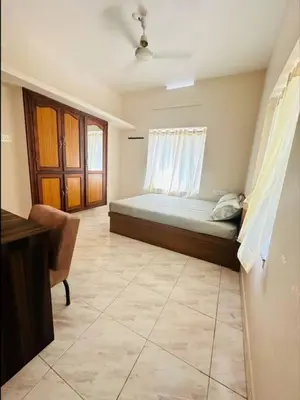 a bedroom with a bed with a window and a desk at Homestay Guruvayur, 2 AC Bedrooms, Hall, Veranda, Kitchen in Guruvāyūr
