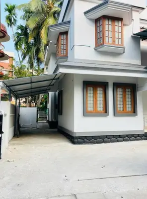 a white house with an awning in front of it at Guruvayur Homestay - 2 AC Bedrooms, Hall & Veranda in Guruvāyūr