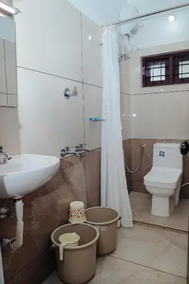 a bathroom with a sink and a toilet and a shower at Sankalpa Homestay in North Paravur